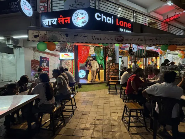 Customers sitting at outdoor tables in front of Chai Lane on a busy evening.