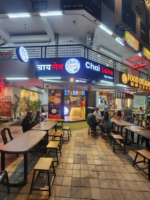 Chai Lane's corner location with its illuminated sign and outdoor seating under the building's arcade.
